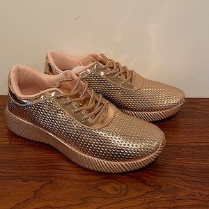 Rose gold sneakers with glittery laces.